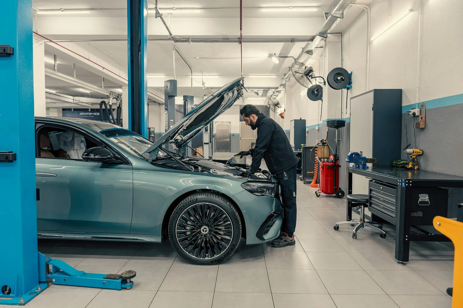 Mecanic care verifică motorul unei mașini într-un atelier auto modern